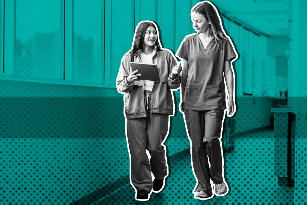 Two healthcare workers in scrubs stand outdoors, one holding a tablet, against a teal building background.