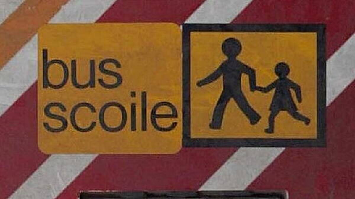 Yellow sign reads “bus school” beside a panel showing two walking children silhouettes.