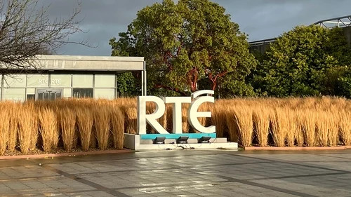 Large “RTE” sign in front of a building, with golden hay bales lining the walkway.